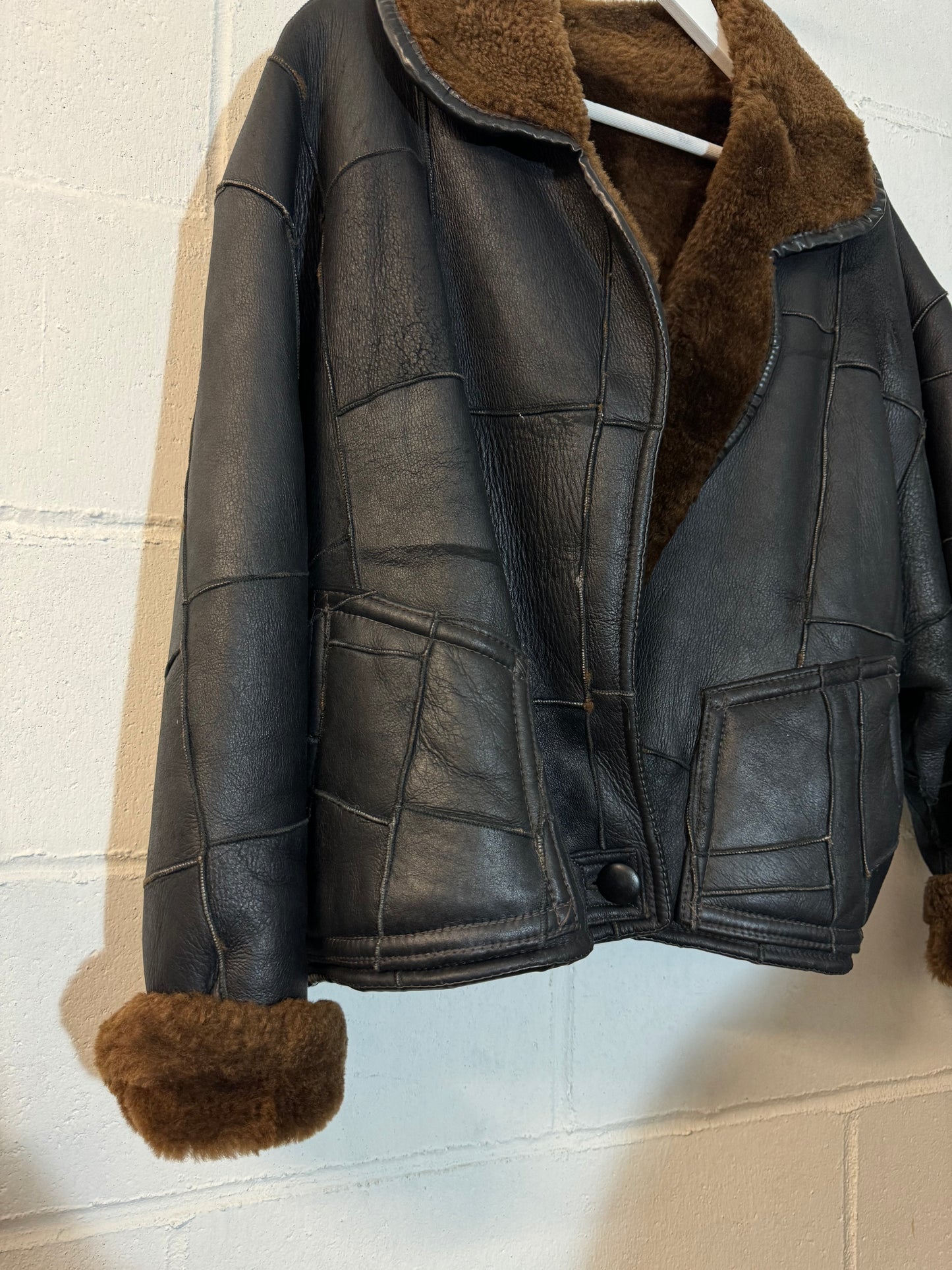 Bomber Shearling cropped. Esterno in nappa nera patchwork, interno a pelo raso cioccolato. Taglia S donna