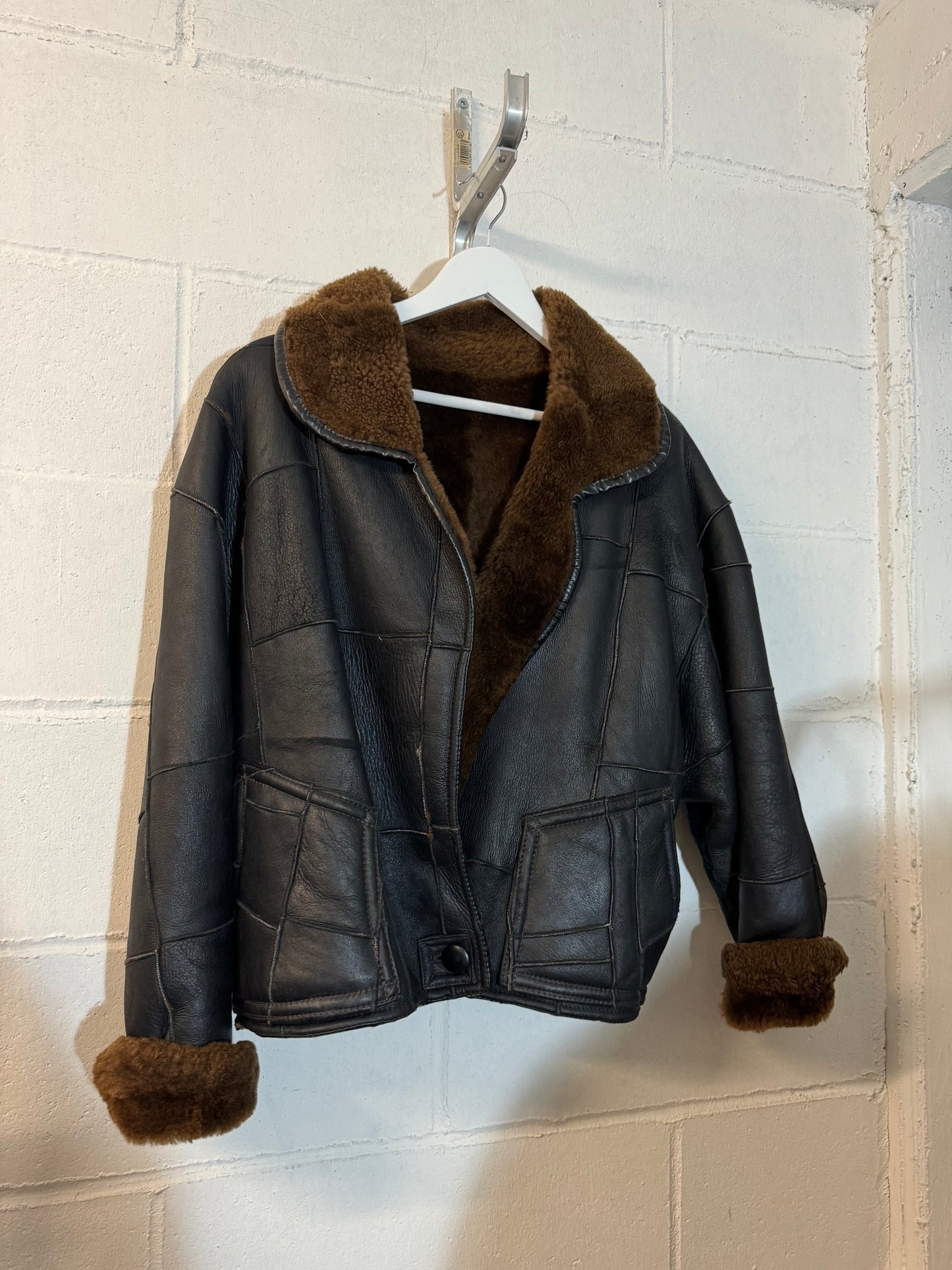 Bomber Shearling cropped. Esterno in nappa nera patchwork, interno a pelo raso cioccolato. Taglia S donna