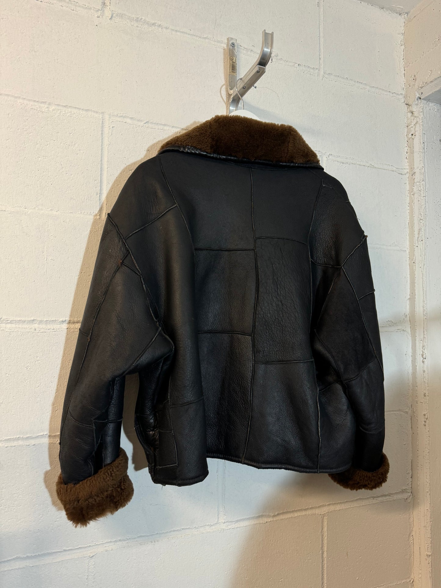 Bomber Shearling cropped. Esterno in nappa nera patchwork, interno a pelo raso cioccolato. Taglia S donna