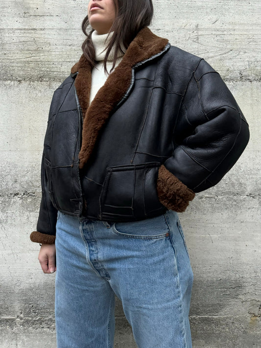 Bomber Shearling cropped. Esterno in nappa nera patchwork, interno a pelo raso cioccolato. Taglia S donna