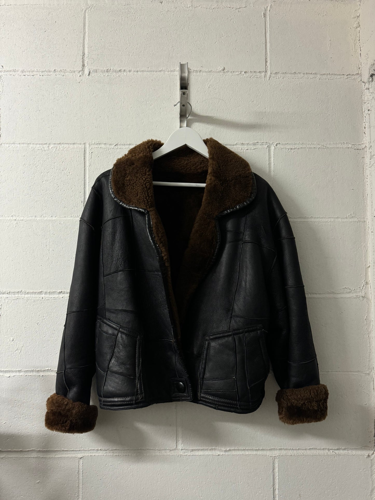 Bomber Shearling cropped. Esterno in nappa nera patchwork, interno a pelo raso cioccolato. Taglia S donna