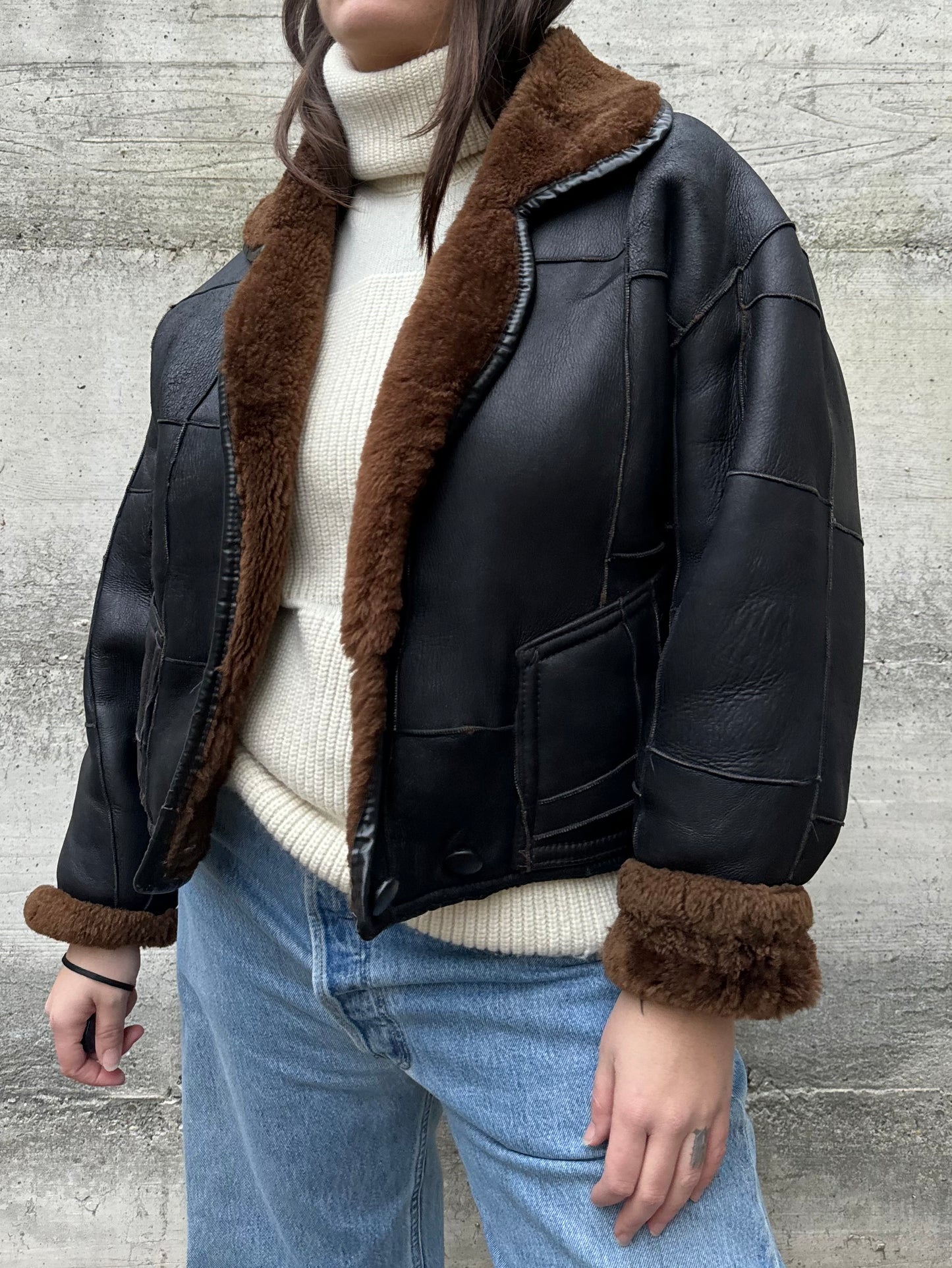 Bomber Shearling cropped. Esterno in nappa nera patchwork, interno a pelo raso cioccolato. Taglia S donna